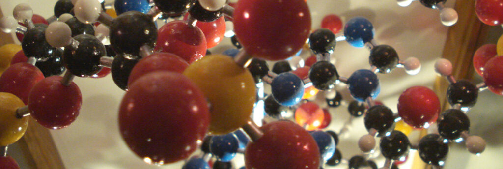 شكل يُظهر نموذج جزيئي مئات الذرات، ممثلة بكرات صفراء وحمراء وسوداء وزرقاء وبيضاء، متصلة ببعضها البعض بواسطة قضبان لتشكيل جزيء.  يحتوي الجزيء على هيكل ثلاثي الأبعاد معقد ولكنه محدد للغاية مع حلقات وفروع